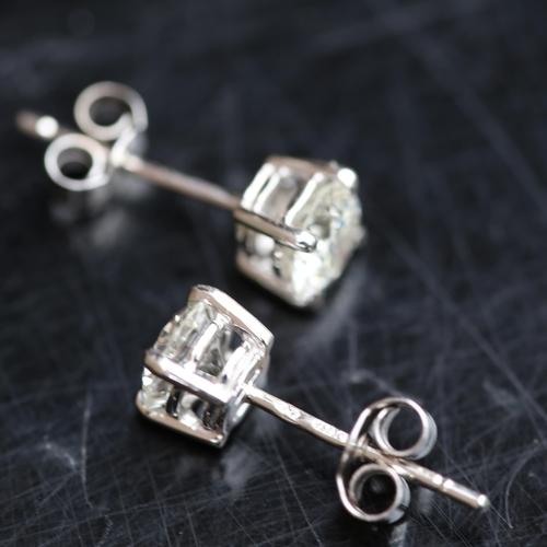 679 - A pair of modern 1.2ct solitaire diamond stud earrings, in 18ct white gold settings with modern roun... 