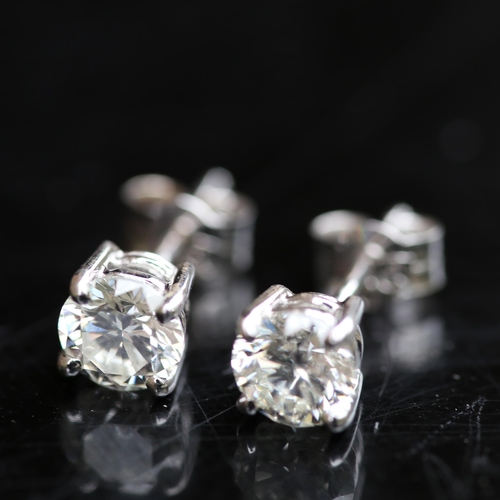 679 - A pair of modern 1.2ct solitaire diamond stud earrings, in 18ct white gold settings with modern roun... 