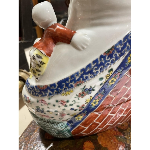 136 - A Chinese porcelain seated Buddha with children, height 26cm, impress mark under base