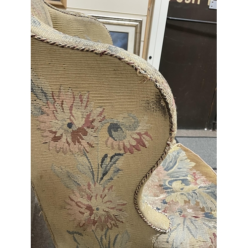 288 - A Georgian wingback armchair, with out-scrolled arms and needlepoint upholstery, raised on carved wa... 