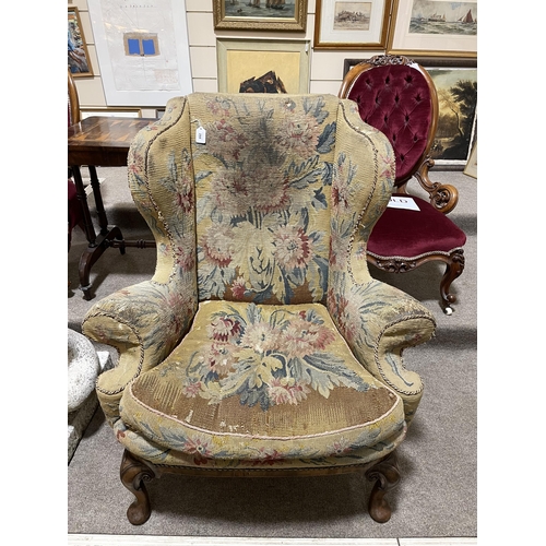 288 - A Georgian wingback armchair, with out-scrolled arms and needlepoint upholstery, raised on carved wa... 