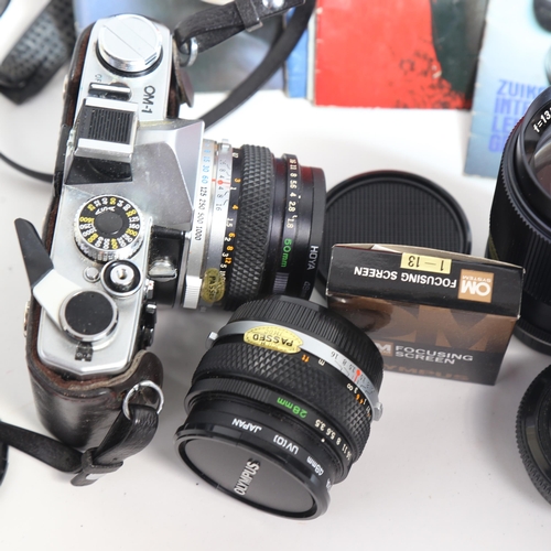 213 - OLYMPUS - a Vintage OM-1 35mm single lens reflex camera, with 2 Olympus lenses and various manuals