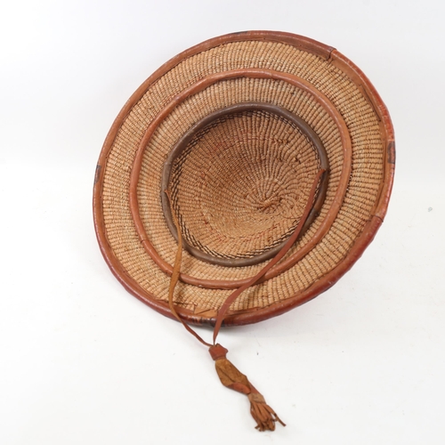 328 - A Cote d’Ivoire basket weave hat with leather band diameter 47cm