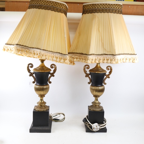 334 - A pair of black and gold urn design table lamps, with matching shades, height 88cm overall