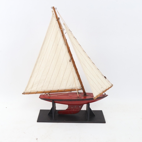 335 - A Vintage Tri-ang painted tin pond yacht, height 39cm, on display stand