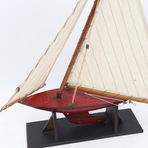 335 - A Vintage Tri-ang painted tin pond yacht, height 39cm, on display stand