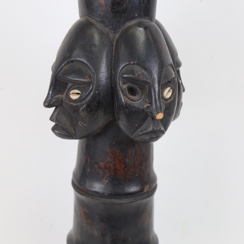 355 - A stained carved wood Ethnic study of 4 heads with inset shell eyes (A/F), height 50cm