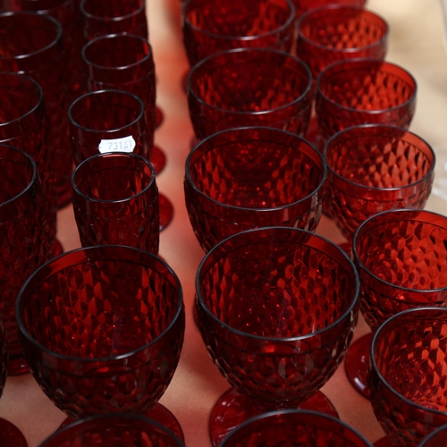 469 - A suite of moulded ruby glassware, including tumblers, goblets and Champagne flutes