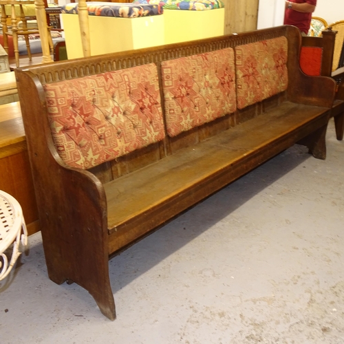 2507 - A large oak settle, with a carved and upholstered back, L244cm, H106cm, D50cm, seat height 46cm and ... 