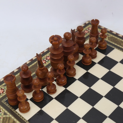 1036 - A turned wood chess set, on board with inlaid decoration, King height 9.5cm