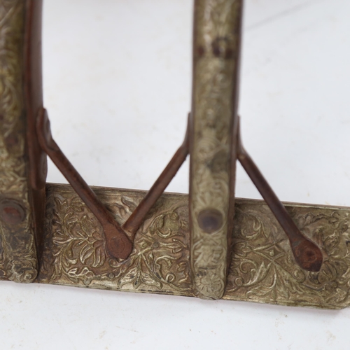 992 - Part of a camel's saddle harness, in wood, iron and embossed brass, length 53cm