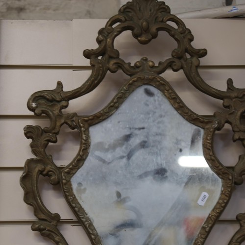 1068 - An ornate wall mirror with shaped edge, height 74cm