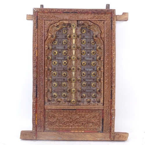 2412 - An ornate Indian hardwood and brass decorated window, with allover relief carved decoration, W60cm, ... 