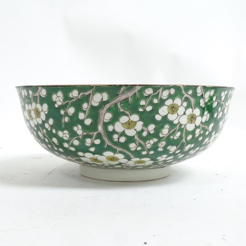 417 - An Oriental green ground porcelain bowl, with prunus decoration, and 2 stands, bowl 24cm diameter