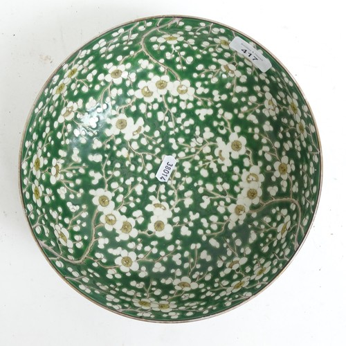 417 - An Oriental green ground porcelain bowl, with prunus decoration, and 2 stands, bowl 24cm diameter