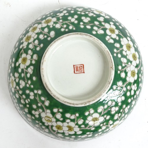 417 - An Oriental green ground porcelain bowl, with prunus decoration, and 2 stands, bowl 24cm diameter