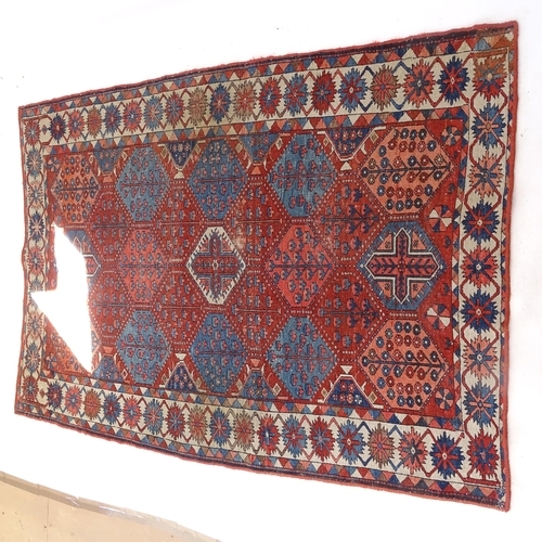 2405 - An Antique red ground Caucasian rug, 200cm x 146cm