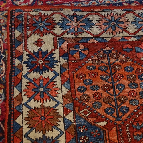 2405 - An Antique red ground Caucasian rug, 200cm x 146cm