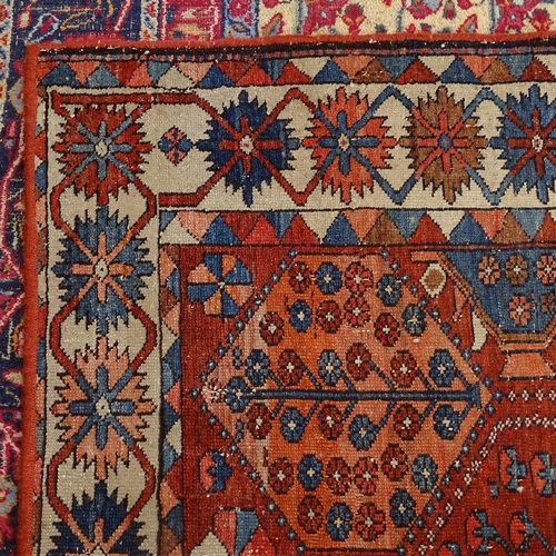 2405 - An Antique red ground Caucasian rug, 200cm x 146cm