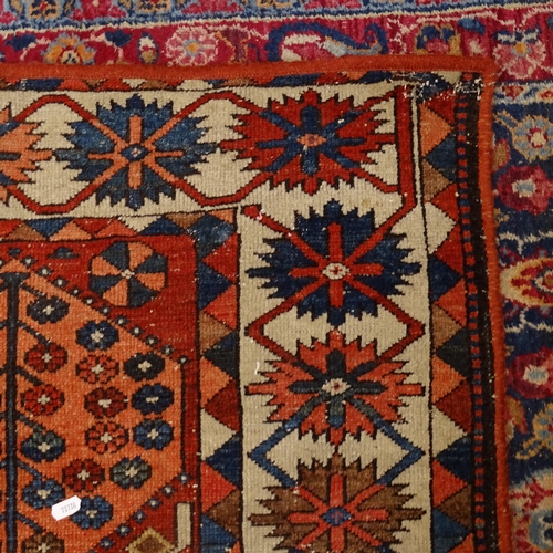 2405 - An Antique red ground Caucasian rug, 200cm x 146cm