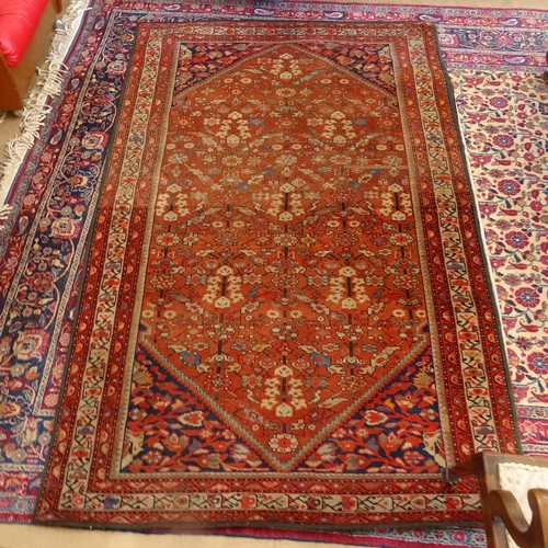 2406 - A red ground Persian Heriz rug, 207cm x 138cm