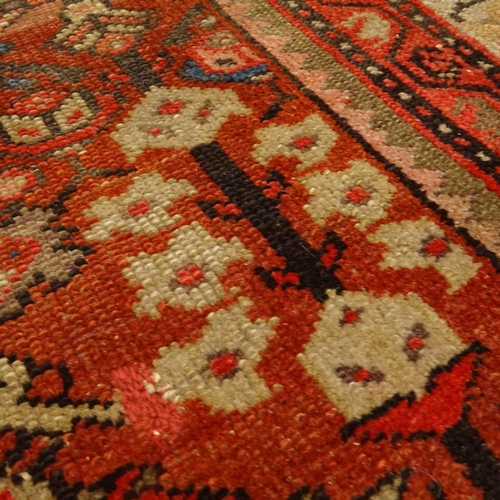 2406 - A red ground Persian Heriz rug, 207cm x 138cm