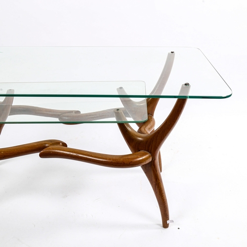 1567 - A mid-century Italian 2-tier glass coffee table, with organic sculptural base in walnut, in the mann... 