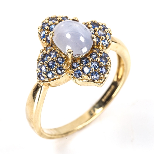 112 - A modern 9ct gold star sapphire flowerhead cluster ring, set with oval cabochon star sapphire and pa... 