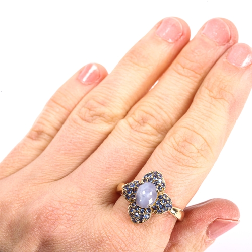 112 - A modern 9ct gold star sapphire flowerhead cluster ring, set with oval cabochon star sapphire and pa... 