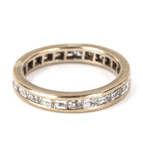 142 - A baguette-cut diamond eternity ring, unmarked white metal settings, band width 3.4mm, size L, 3.2g