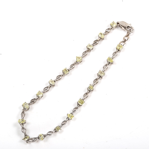 84 - A modern 18ct white gold fancy yellow diamond line bracelet, set with vari-cut yellow diamonds, incl... 