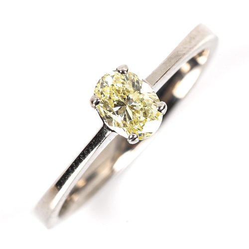 86 - A modern 18ct white gold 0.5ct fancy yellow solitaire diamond ring, plain 4-claw setting with oval b... 