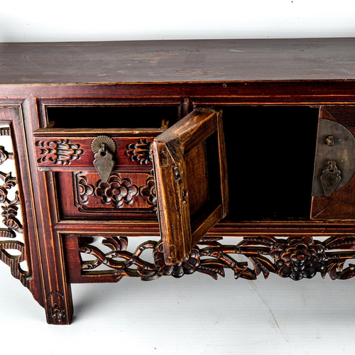 1016 - A Chinese stained wood altar table of small size, with 4 small carved drawers and central cupboard f... 