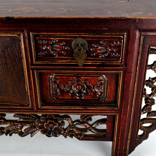 1016 - A Chinese stained wood altar table of small size, with 4 small carved drawers and central cupboard f... 