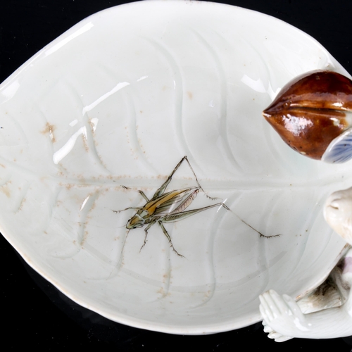 1017 - A Japanese Hilrado white glaze porcelain dish in the form of a monkey holding a leaf, with painted l... 