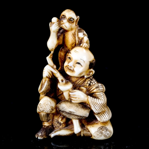 1023 - A Japanese ivory okimono depicting a man with a monkey on his shoulder, Meiji Period, signed under b... 