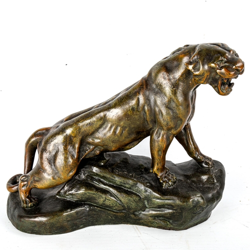 1038 - A bronze patinated spelter figure of a lioness, signed Cartier on the base, length 29cm