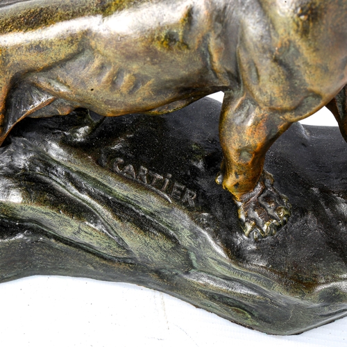 1038 - A bronze patinated spelter figure of a lioness, signed Cartier on the base, length 29cm