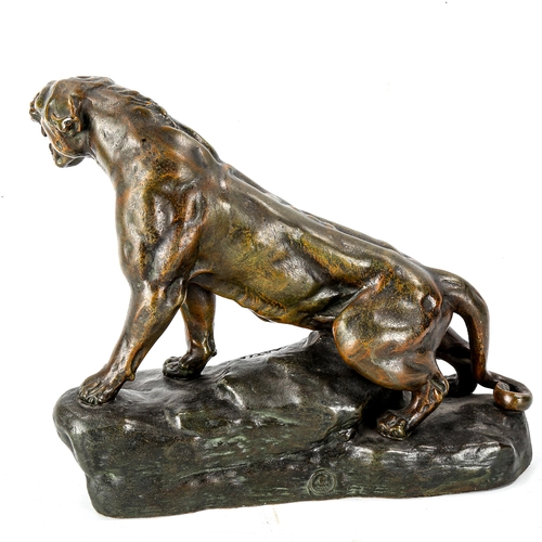 1038 - A bronze patinated spelter figure of a lioness, signed Cartier on the base, length 29cm