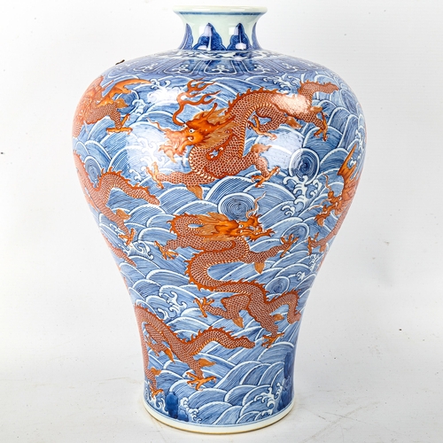 1071 - A Chinese blue and red painted porcelain vase, with dragon and sea design, seal mark, height 34cm