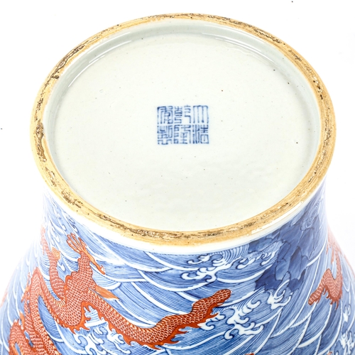 1071 - A Chinese blue and red painted porcelain vase, with dragon and sea design, seal mark, height 34cm