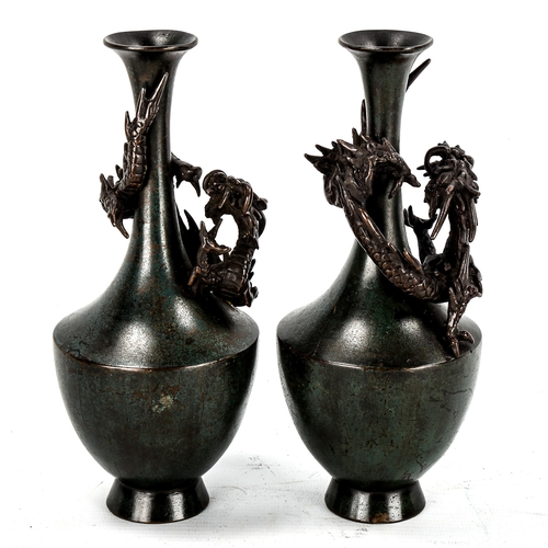 1131 - A pair of Chinese verdigris patinated bronze vases, with dragon mounted necks, signed under base, he... 