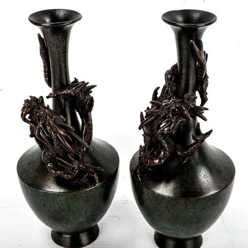 1131 - A pair of Chinese verdigris patinated bronze vases, with dragon mounted necks, signed under base, he... 