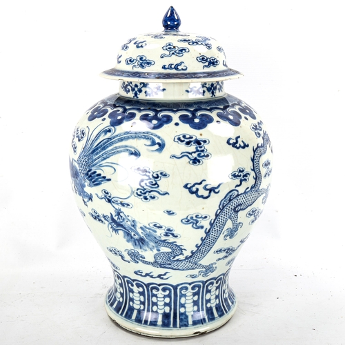 1202 - A large Chinese blue and white porcelain jar and cover, decorated with dragons and exotic birds, 6 c... 