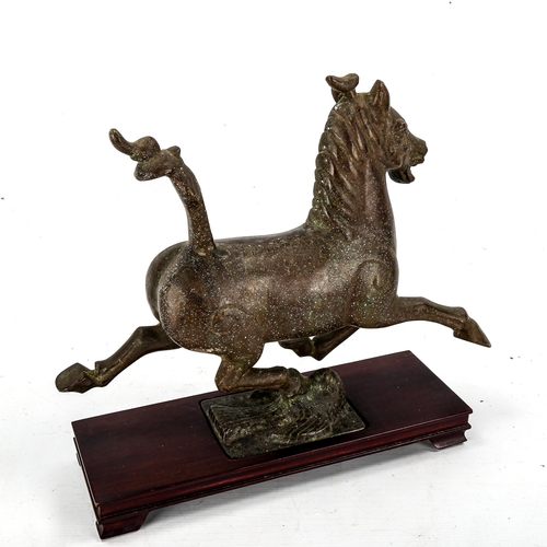 1204 - A Chinese patinated bronze sculpture of a running horse on wood plinth base, length 35cm