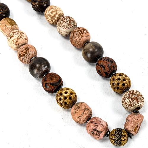 1236 - A string of Chinese beads, including terracotta heads, horn beads, and pierced ivory