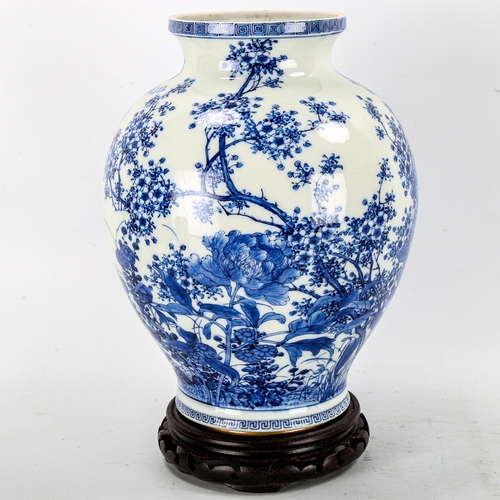 1245 - A Chinese blue and white porcelain vase with painted detailed floral design, attached wood base, hei... 