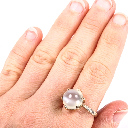 182 - A modern moonstone and diamond dress ring, unmarked gold settings with large round cabochon moonston... 