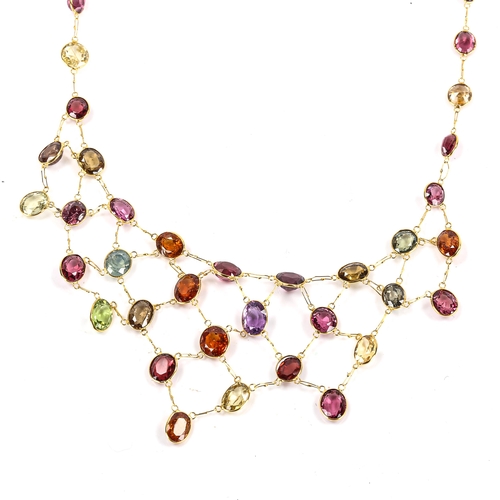 243 - A modern 14ct gold gem set bib necklace, gemstones include amethyst, peridot, garnet, citrine, topaz... 