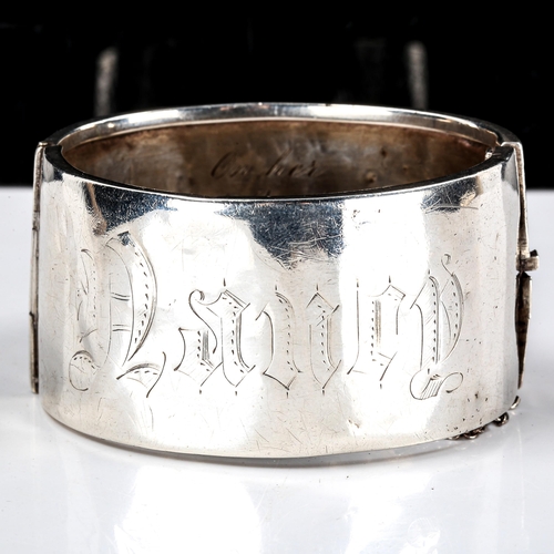 298 - A Victorian unmarked silver hinged cuff bangle, engraved leaf decoration with inscription dated 1882... 